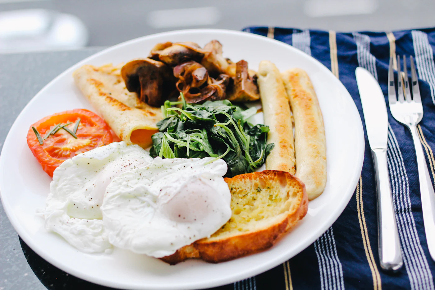 Plato de brunch con tostadas, tomate asado y semillas sobre una mesa clara